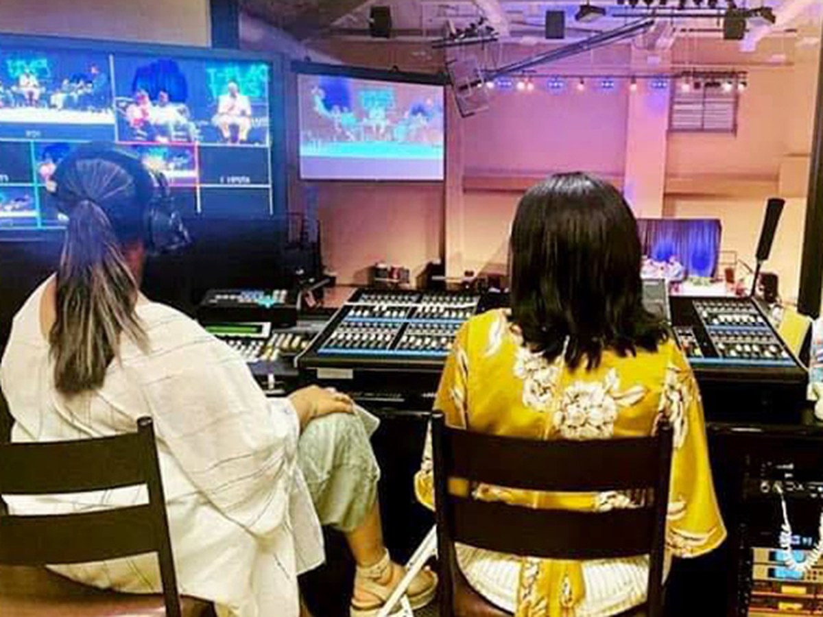 Production team operating audio and video boards during a live broadcast